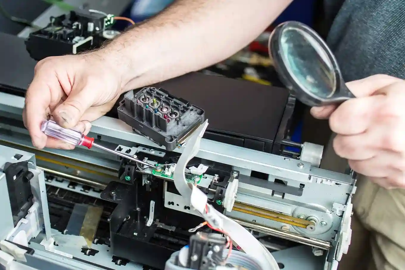 Technician inspecting internal printer components during HP DesignJet Repair service.
