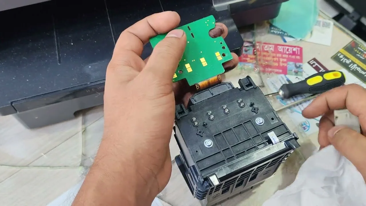 Technician holding an internal printer component during HP Plotter Repair Services.